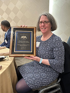 Dina Kastner holds the award